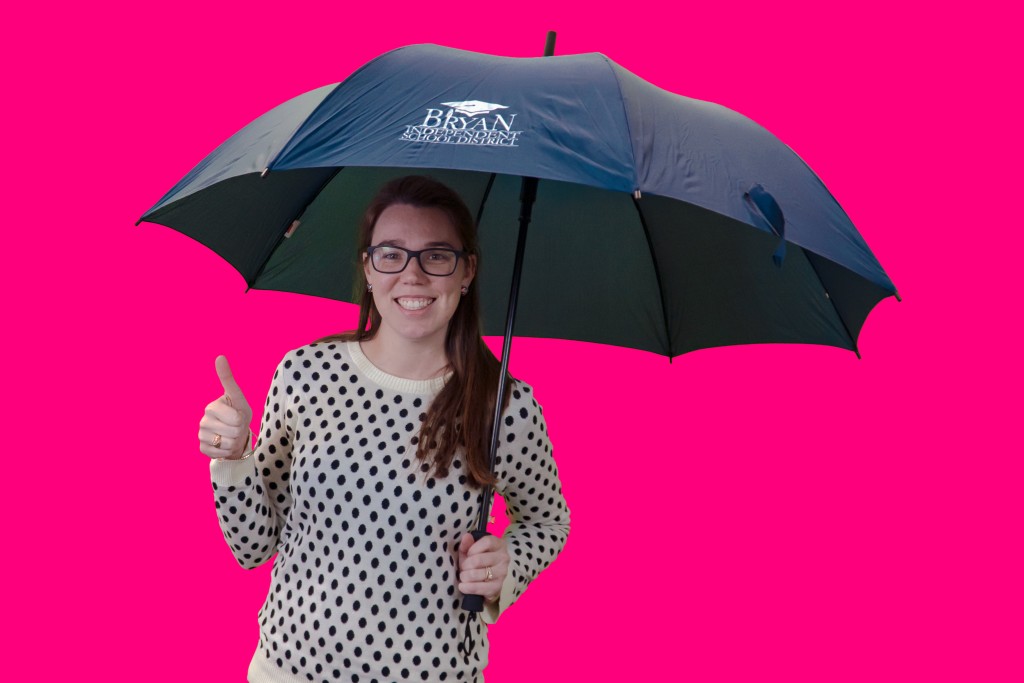 Bryan ISD prize winner giving a thumbs up sign while holding an umbrella